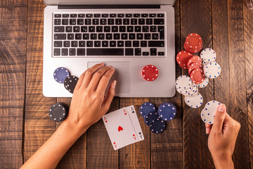 Online betting or poker. Top view of a computer with chips and cards for betting or playing. Online...