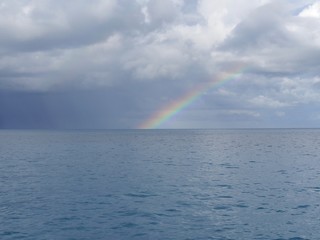 Faint rainbow touching the water's edge