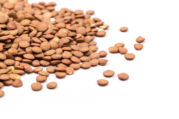 Isolated stack of uncooked lentils on white background from above.