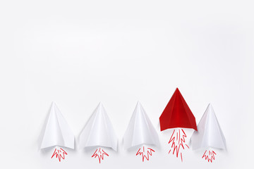 Group of white paper plane in one direction and one red paper plane pointing in different way on white background. Business for innovative