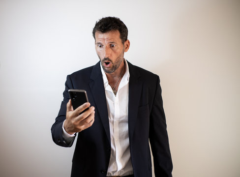 hombre de negocios con cara de sorpresa al mirar su smartphone