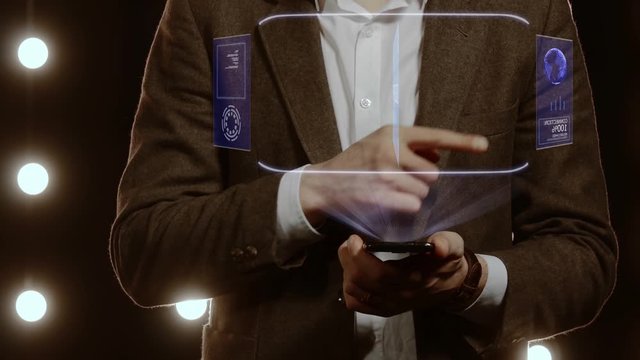 Businessman activates conceptual HUD hologram on smartphone with text Developer. Man in a white shirt and jacket with a holographic screen on the background of lights