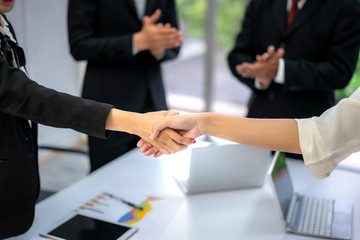 Business people shaking hands, finishing up a meeting to seal a deal with his partner business with colleague clap hands to congrats.