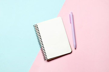 Notebook with pen on a blue and pink background. Place for text