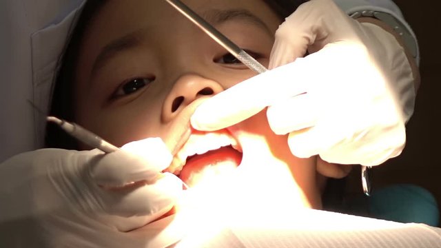 Dentist check-up teeth to little girl patient at dental clinic
