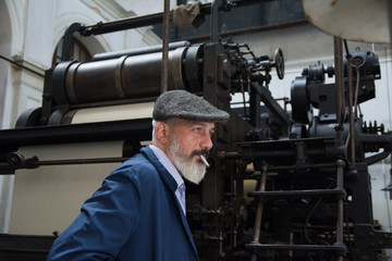 Man with beard working on printing press