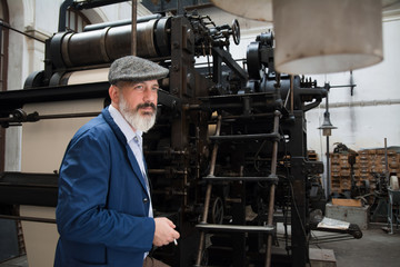 Man with beard working on printing press