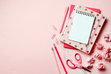 Pink notebook on a pink background with pink school supplies. Place for text. Top view