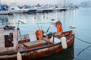 Fototapeta na wymiar Barcaza pesquera antigua color naranja en el puerto