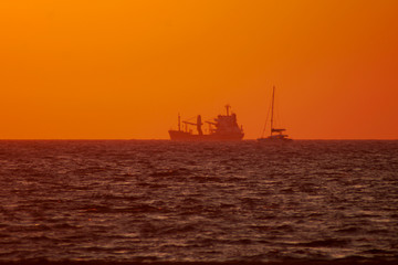 Fototapeta na wymiar Barco en la mar al anochecer en Chipiona, Cádiz