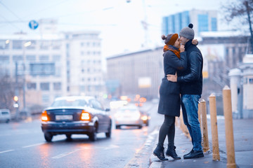 young man and woman hugging kissing outside
