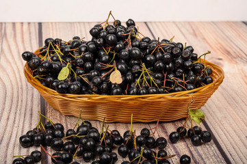 Ripe Aronia berries in a wicker basket on the table