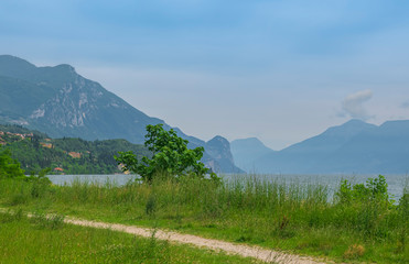 Panoramic views of the shore and mountains of lake Garda on a clear Sunny day.