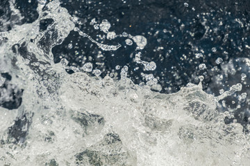 Splash of fresh water with drops caught in the air with turquoise river surface in the background  