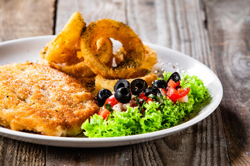 Fried pork chop, onion rings and vegetables