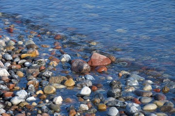 Bunte Steine am Strand vom Meer umspült