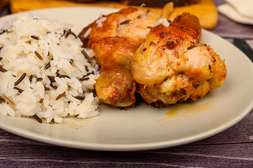 Chicken legs with spices fried in a cauldron, Served on a plate with rice