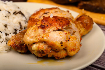 Chicken legs with spices fried in a cauldron, Served on a plate with rice