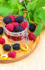 They look like artificial treats! But they are delicious and beautiful blackberries and fresh raspberries. Isolated on white background.