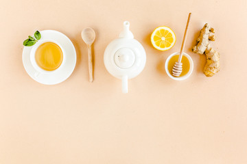 Herbal tea with mint, ginger, lemon, honey and other herbs on yellow background. Flat lay, top view.