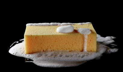 Soap foam with bubbles and sponge isolated on black background