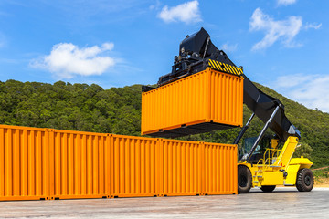 Reach stacker yellow forklift truck handling shipping container in business import export logistic...