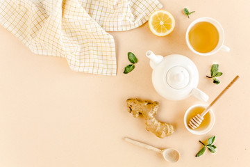 Fototapeta na wymiar Herbal tea with mint, ginger, lemon, honey and other herbs on yellow background. Flat lay, top view.