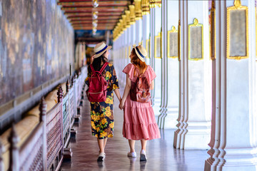 young tourist women walking through the palace temple in Bangkok of Thailand, Emerald Buddha Temple, Wat Phra Kaew, Bangkok Royal Palace popular tourist place