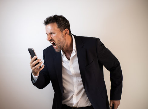 hombre de negocios enfadado y agresivo hablando con el smartphone