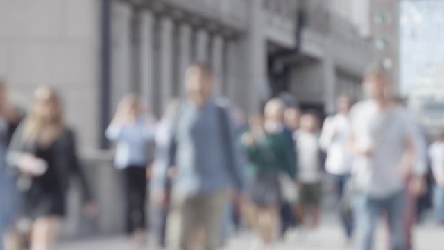 Wide angle blurred background of pedestrians in the city walking, in slow motion