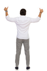 Elegant Man In Gray Trousers And White Shirt Is Standing And Showing Thumbs Up. Rear View.