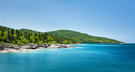 Scenic view of the forest across the beautiful Blue water of Lake Superior at Neys Provincial Park,...