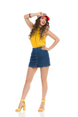 Happy Young Woman In Jeans Mini Skirt And High Heels Is Posing In Red Sun Visor Cap
