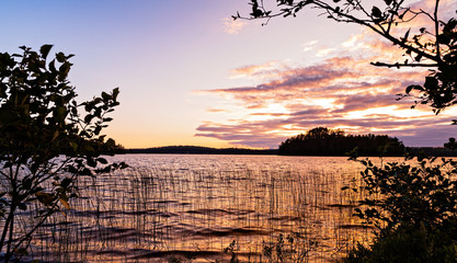 Sunset View on a lake framed by silhouetted trees from the shores of French Lake at Chippewa campground in Quetico Provincial Park, Atikokan, Ontario, Canada - obrazy, fototapety, plakaty