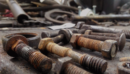 Rusty bolts, nuts and some steel tools in an old warehouse workshop