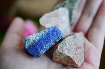 Rough crystals in woman's hand with natural lighting. Raw Rose Quartz, Raw Lapis Lazuli, Raw...