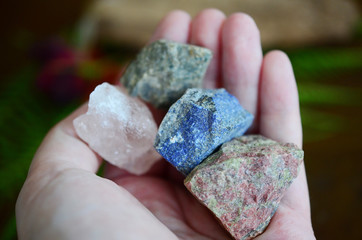 Rough crystals in woman's hand with natural lighting. Raw Rose Quartz, Raw Lapis Lazuli, Raw...