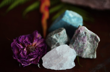 Rough crystals in woman's hand with natural lighting. Raw Rose Quartz, Raw Lapis Lazuli, Raw Unakite, and Raw Ocean Jasper. Beautiful crystal display, crystals and plants, macro photography