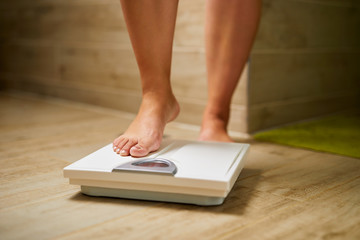 Female bare feet while weighing on scale weight in a bathroom