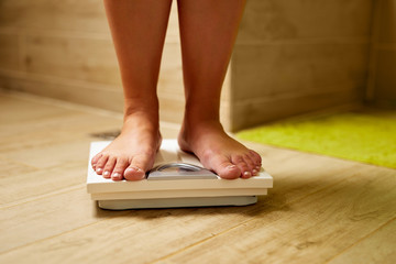 Female bare feet on weight scale in a bathroom