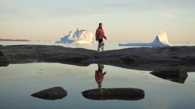 Full length of woman in Greenlandic dress walking on rock in Disko Bay