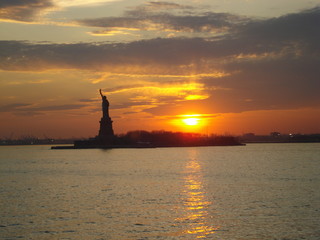 Fototapeta na wymiar Sunset Featuring The Statue Of Liberty