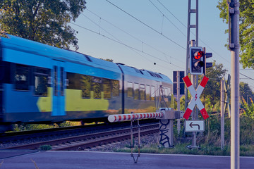 Obraz premium Traffic sign at a railroad crossing, In the background a train