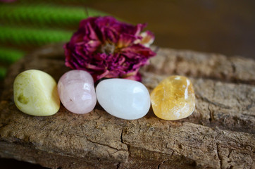 Fototapeta na wymiar Positivity Crystals, Mindfulness. Tumbled Crystal Bundle: Rose Quartz, Citrine, Serpentine, and Milky Quartz. Energy Spring Cleaning. Variety of healing crystals, pastel colors in natural lighting