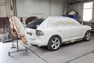 Painting the right side of a white SUV car after an accident. Auto service industry.
