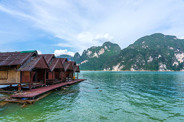 Fototapeta na wymiar Wooden raft houses on lake with mountain background