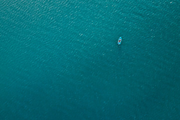 Aerial photo of a small fishing boat in the blue sea