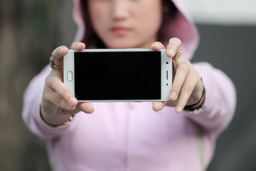 a woman holding a cellphone with the front facing