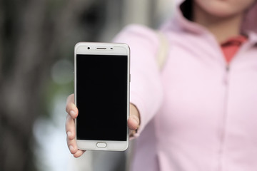 a woman holding a cellphone with the front facing