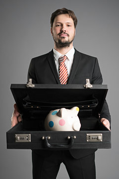 businessman with briefcase and a piggy-bank in it